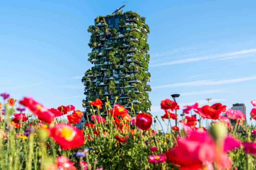 Edificio verde con piante e fiori colorati in primo piano.