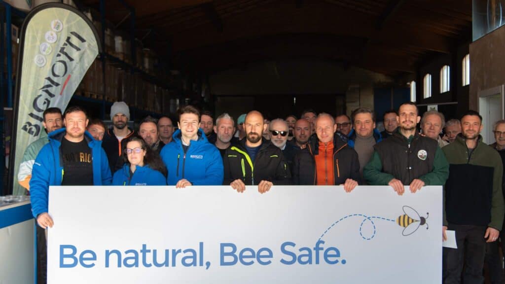 Gruppo di persone con cartello Be natural, Bee Safe in un evento.